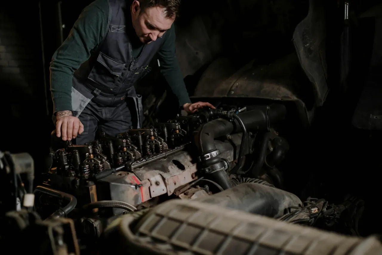 A Floorjack technician inspecting an engine under low light